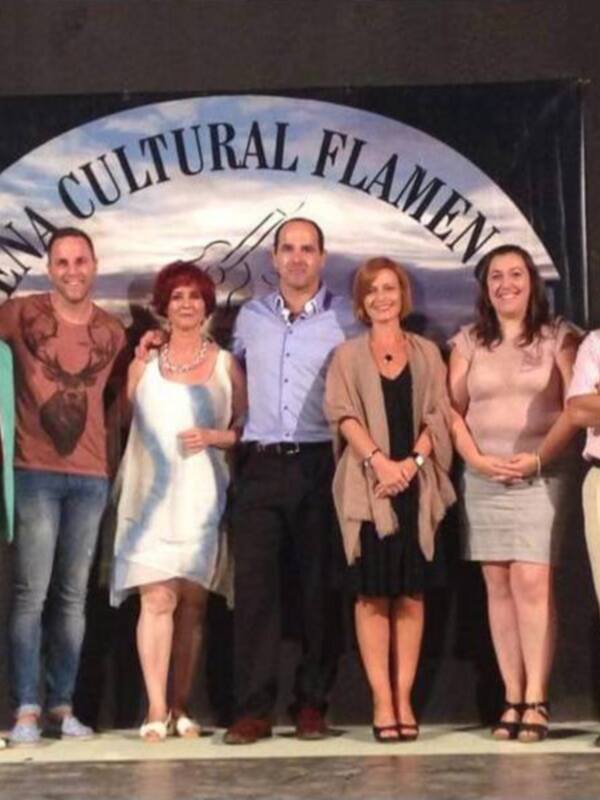 Grupo de personas posando en el escenario de la Feria Cultural Flamenca.