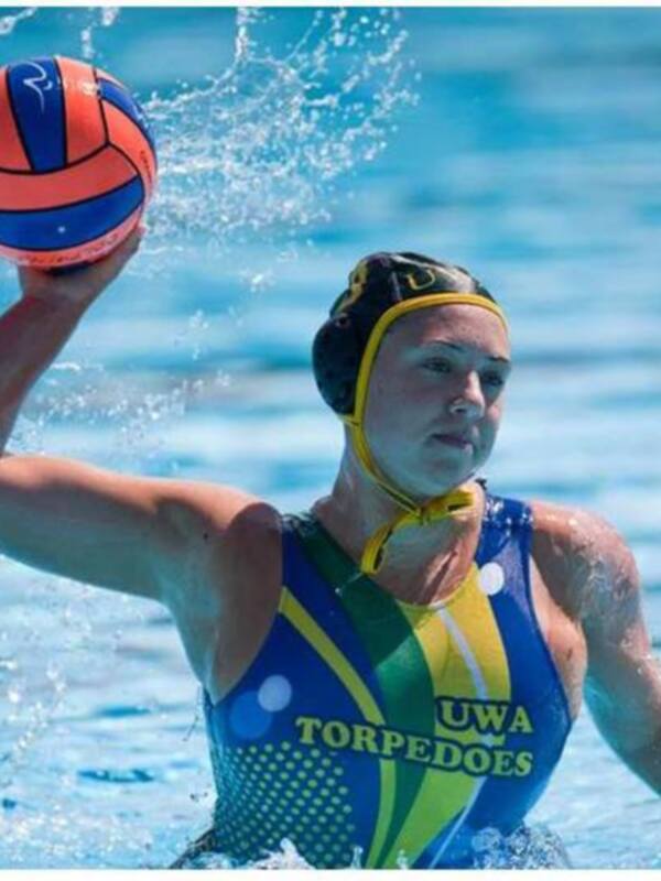 Jugadora de waterpolo en acción, sosteniendo el balón en el agua.