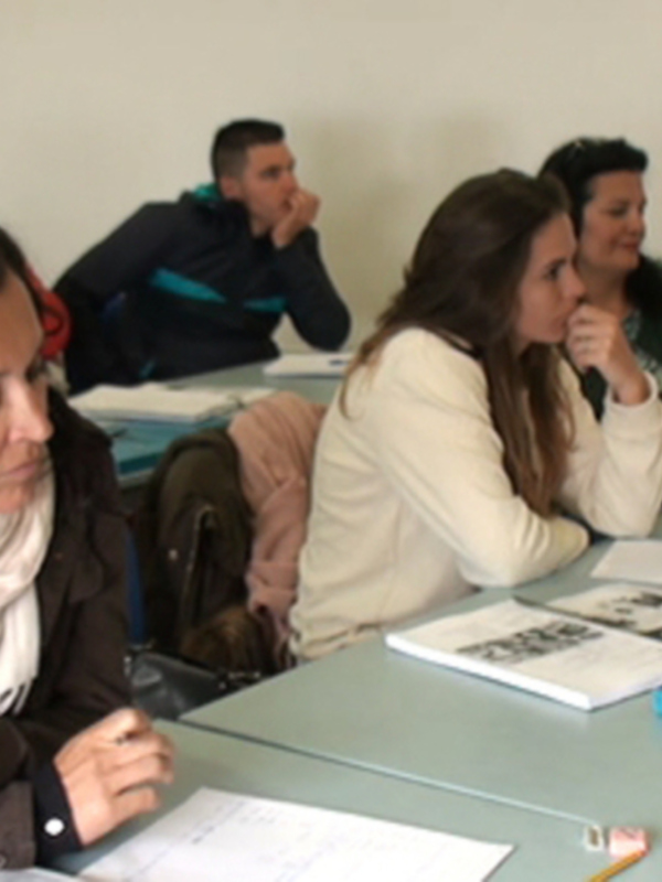 Grupo de estudiantes participando activamente en una clase de aula.