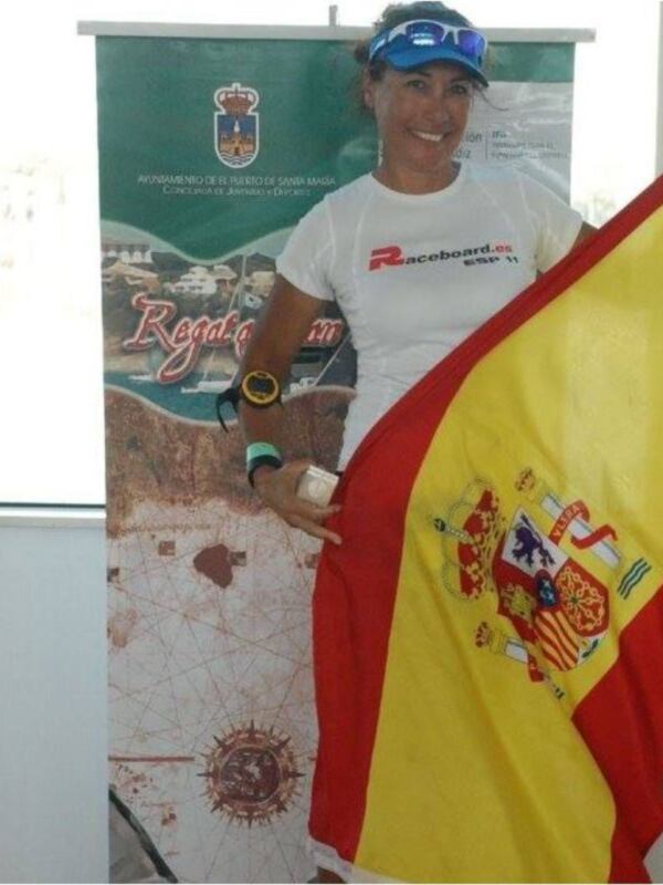 Persona sosteniendo una bandera española en un evento deportivo.