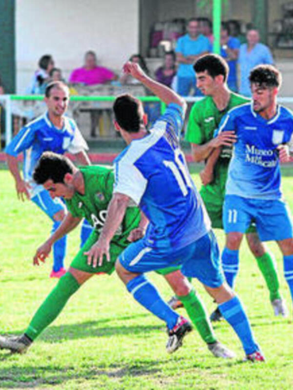 Jugadores en acción durante un partido de fútbol en un estadio local.