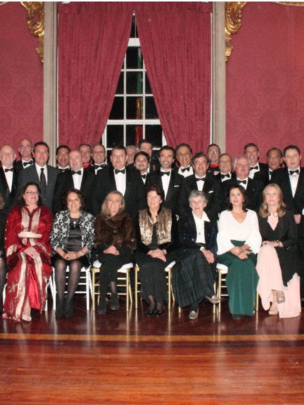 Gratuito de una reunión formal en un salón de eventos con personas vestidas de gala.