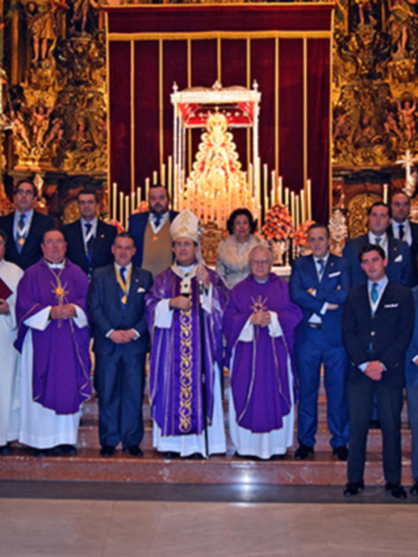 Celebración religiosa en una catedral, con sacerdotes y personas vestidas formalmente posando para una foto.