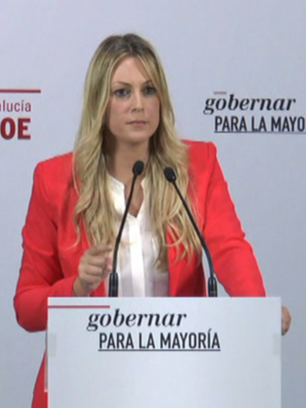 Mujer hablando en un podium con el lema 'gobinar para la mayoría' y el logo del PSOE en el fondo.