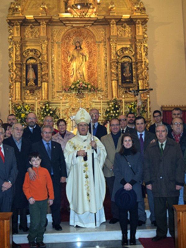 Celebración religiosa en una iglesia con un sacerdote y una multitud de personas posando para una foto.