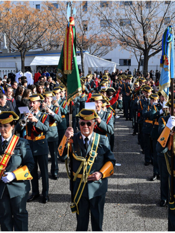 Desfile militar con bandas de música y uniformes tradicionales en una celebración pública.