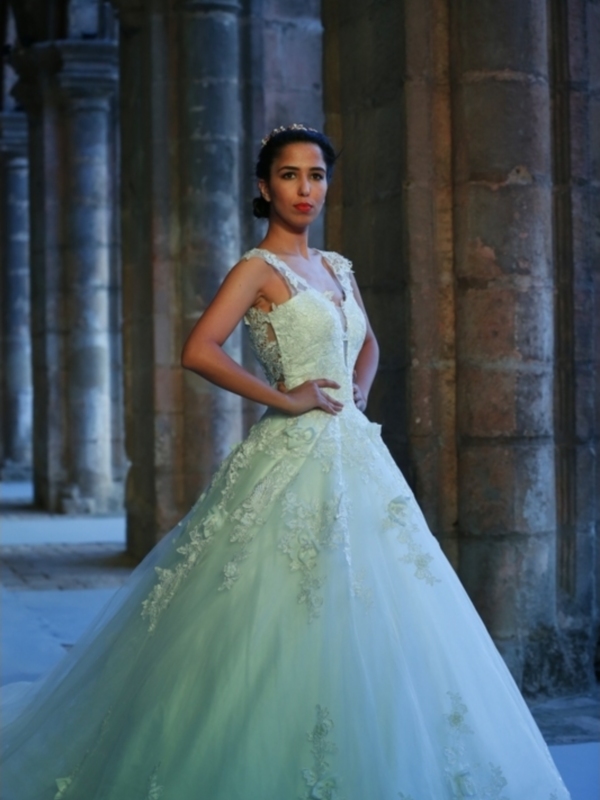 Elegante vestido de novia con detalles florales en un entorno histórico.