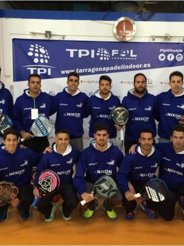 Equipo de padel posando en el evento TPI en Tarragona, con sudaderas azules de sponsorización de NIXON y raquetas de padel en la mano.