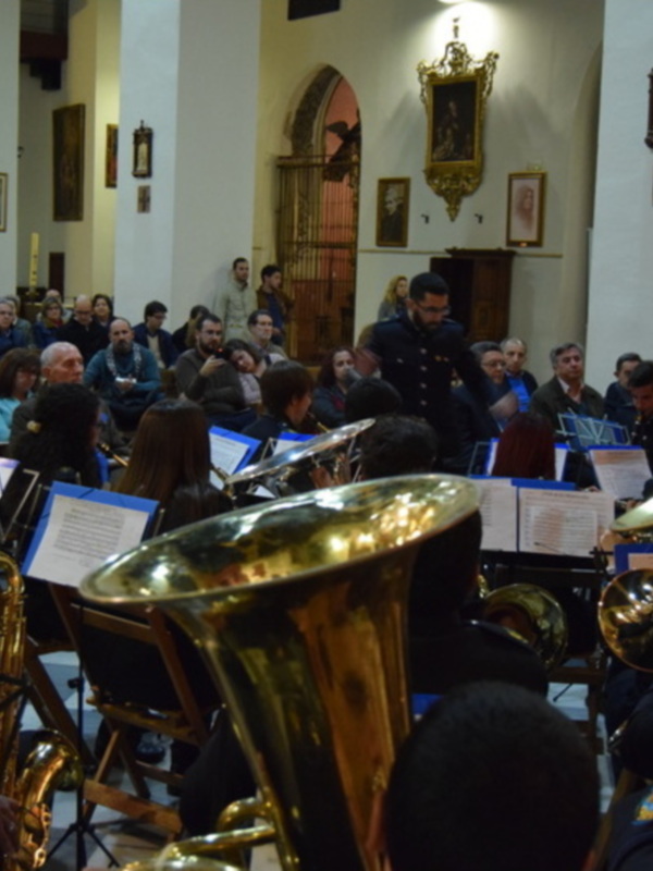 Orquesta de música barroca en una iglesia, con instrumentos como trombones y tubas en el frente.