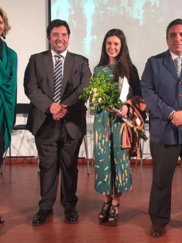 Una celebración formal con tres personas posando en una escena de presentación.