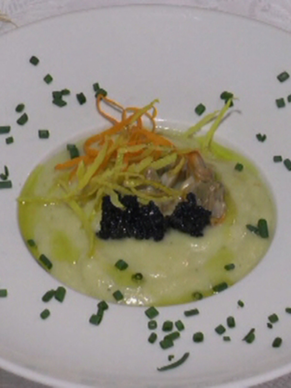 Delicado plato de caviar y verduras en crema, adornado con hierbas y hilo de cebolla.