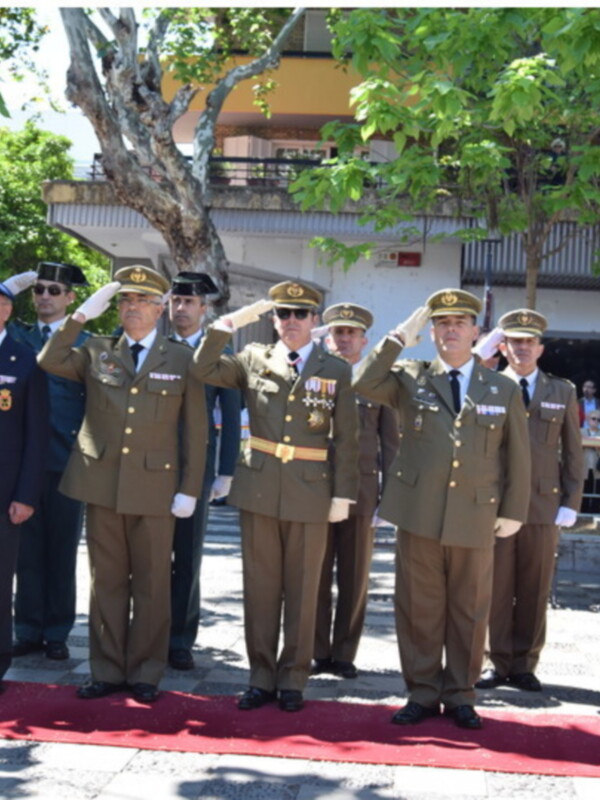Oficiales militares saludando en una ceremonia al aire libre.