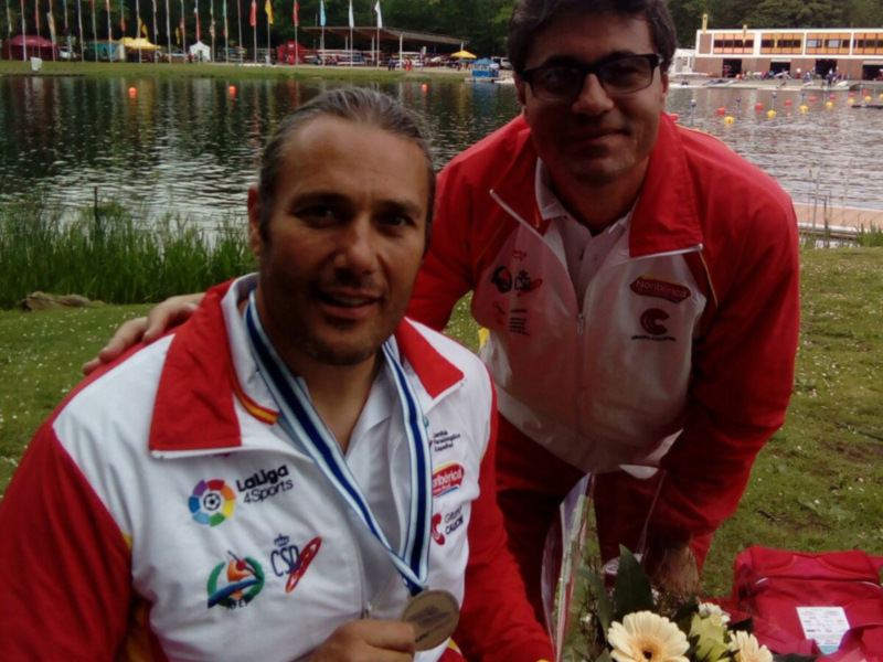 Dos atletas celebran una victoria con medallas y flores en un entorno acuático.