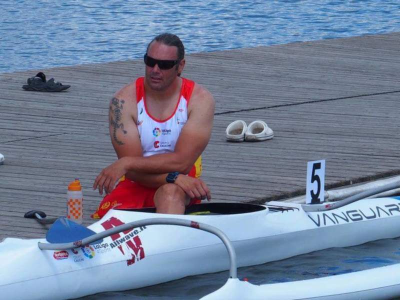 Atleta de remo sentado en un puerto fluvial, preparado para competir.