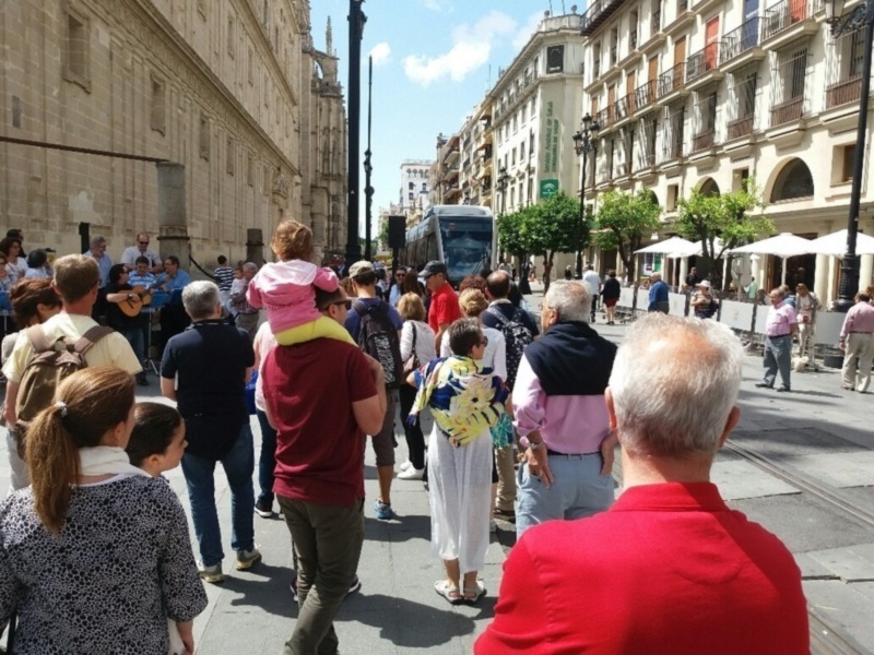 Paseo en la Plaza de San Francisco, Sevilla, con gente caminando y disfrutando del ambiente.