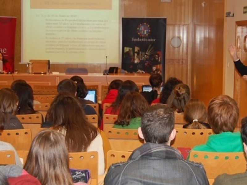Presentación en sala de conferencias con un ponente y una audiencia atenta.