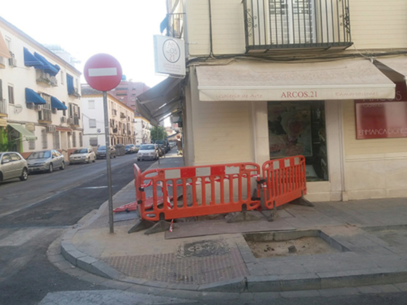 Barriada urbana con obra en construcción y señal de prohibido el paso en rojo.