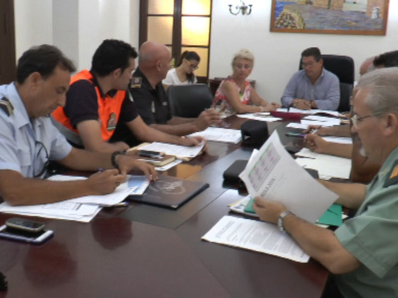 Una reunión de trabajo en una oficina con personas sentadas en una mesa, revisando documentos y discutiendo.