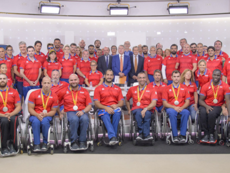 Equipo de atletas en silla de ruedas posando para una foto en un evento deportivo.