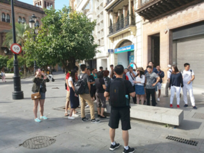 Turistas a la sombra de un naranjo