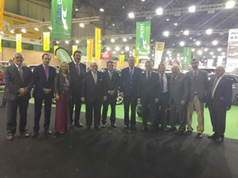 Grupo de personas posando juntos en un evento de negocios en un salón de exposiciones.