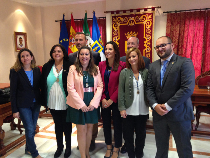 Reunión oficial en un salón con banderas y decoración formal.