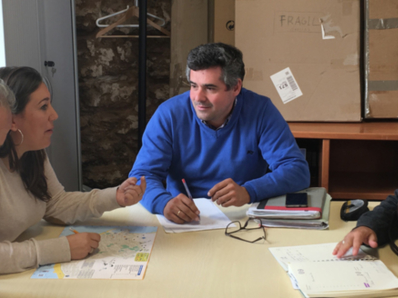 Reunión de trabajo en una oficina, personas discutiendo y analizando documentos.