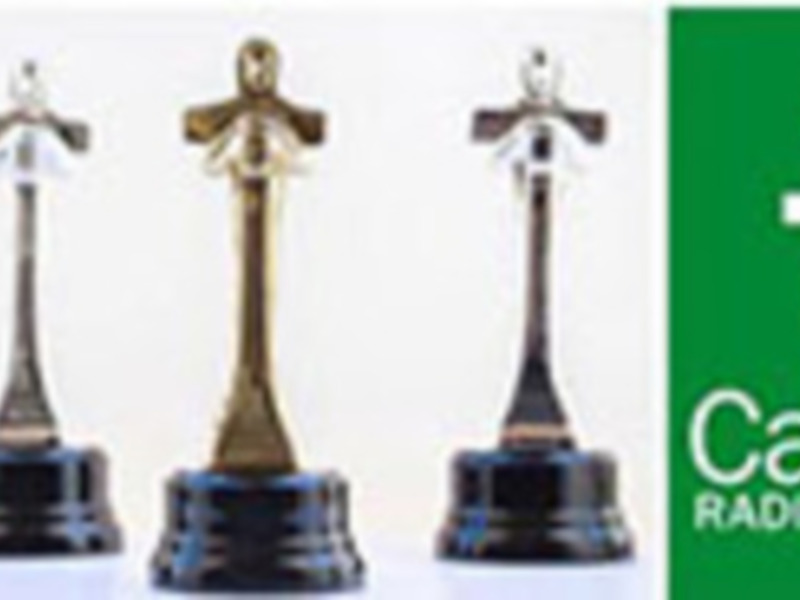 Tres estatuillas de premio de diferentes tamaños y colores, junto con el logo de Canal Sur Radio y Televisión.
