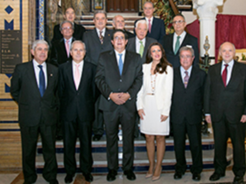 Grupo de personas posando para una foto en un entorno formal, posiblemente en una reunión o evento empresarial.