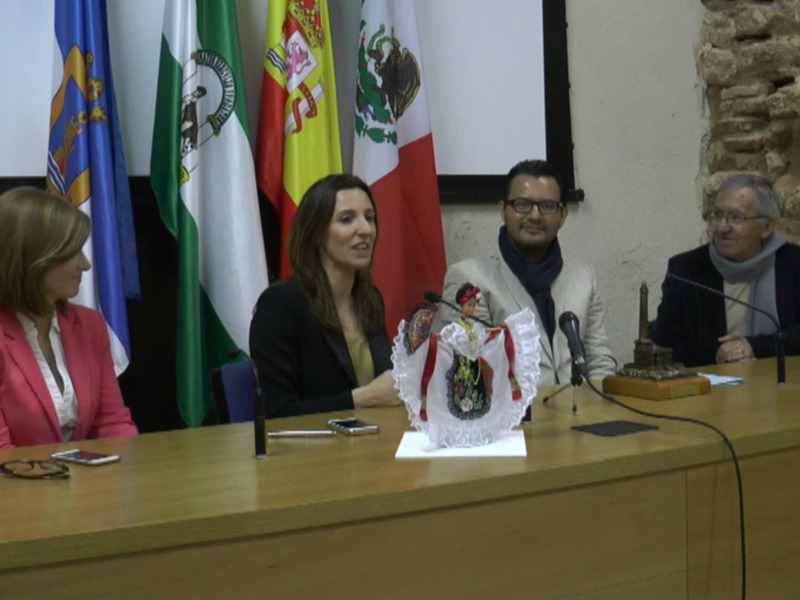 Conferencia de prensa con banderas y representantes sentados en una mesa.