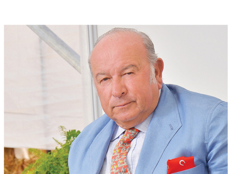 Retrato de un hombre con traje azul y corbata de patrón, con un pañuelo rojo en el bolsillo del chaleco.