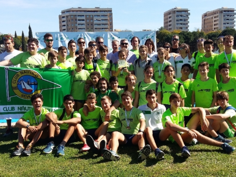 Equipo del Club Náutico Sevilla celebrando un éxito deportivo junto a su bandera.