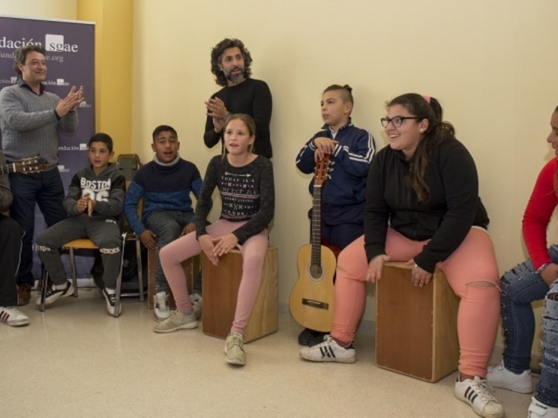 Niños y jóvenes participando en una actividad musical en un entorno educativo.