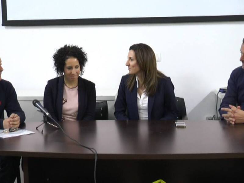 Reunión de trabajo en una sala de conferencias con cuatro personas sentadas alrededor de una mesa.