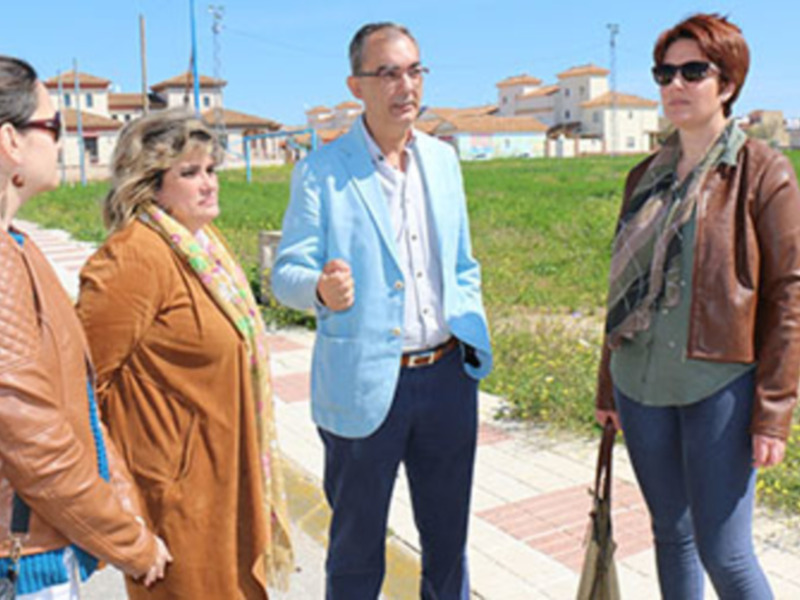 Grupos de personas conversando en un entorno urbano con edificios en el fondo.