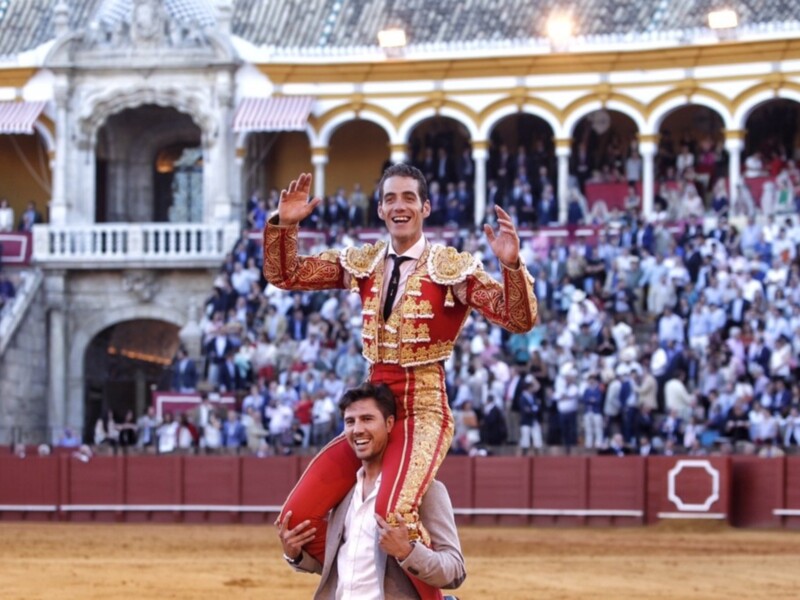 Amigos celebrando una corrida de toros en el famoso recinto de la Plaza de Toros de la Real Maestranza de Sevilla, España.