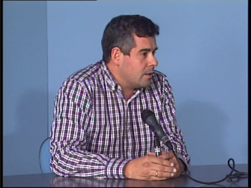 Persona hablando en un micrófono durante una reunión o conferencia.