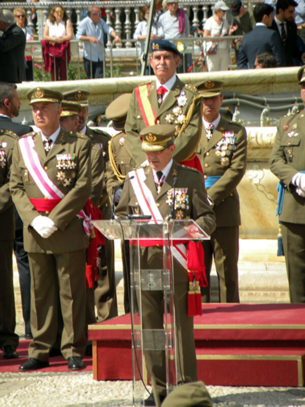Militar en uniforme militar con medallas hablando desde un podio en una ceremonia pública.