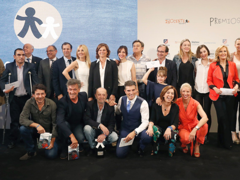 Premiados en los Premios INOCENTE celebrados en la sede de la Fundación Atlético Madrid, con un logo de la organización en el fondo.