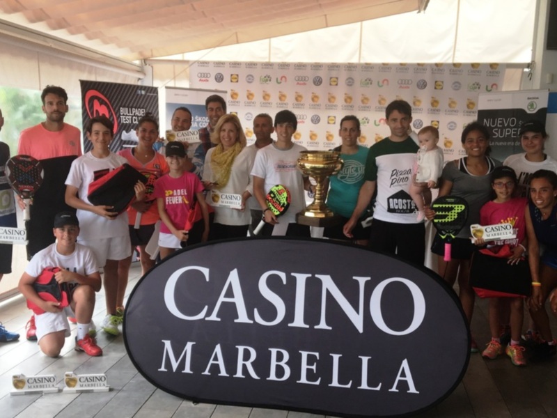 Equipo de padel posando con trofeos y firmas de patrocinadores en Casino Marbella.