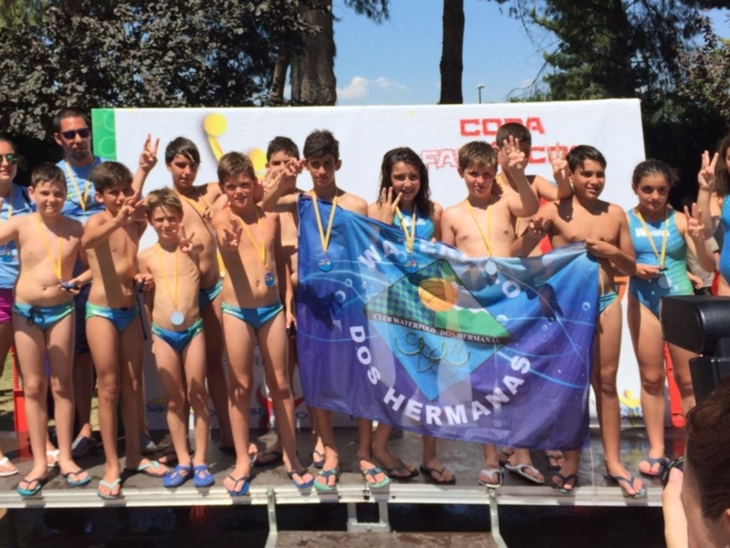 Equipo juvenil de waterpolo celebrando en el podio tras una competición.
