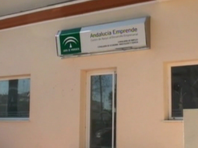 Placa informativa 'Andalucía Emprende' en una fachada de edificio.
