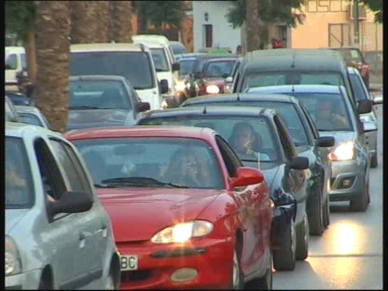 Street traffic jam with multiple cars stopped in a line.