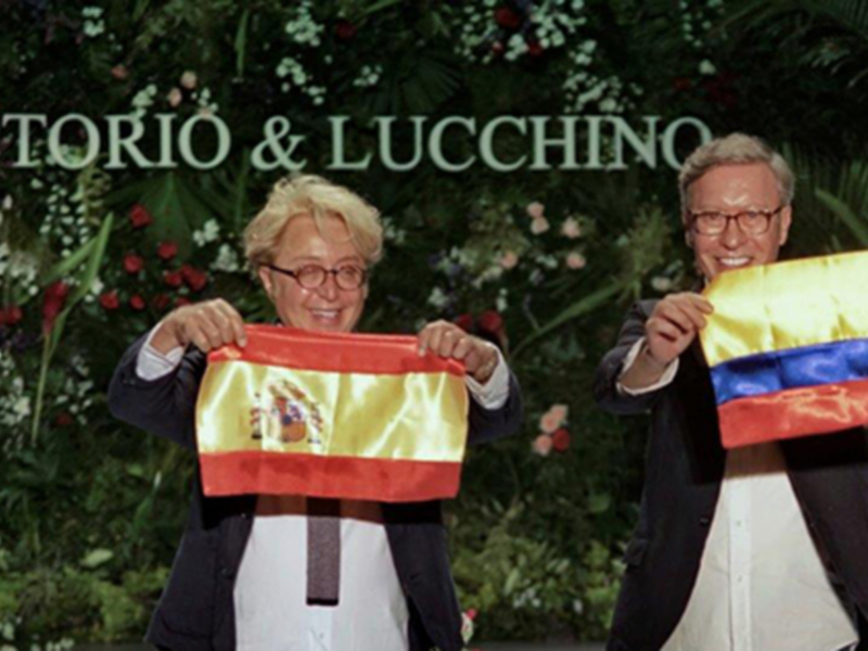 Celebración con banderas de España y Colombia bajo el letrero 'VICTORIO & LUCCHINO'.