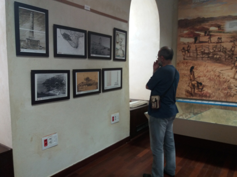 Persona observando una exposición de imágenes históricas y artefactos en un museo.