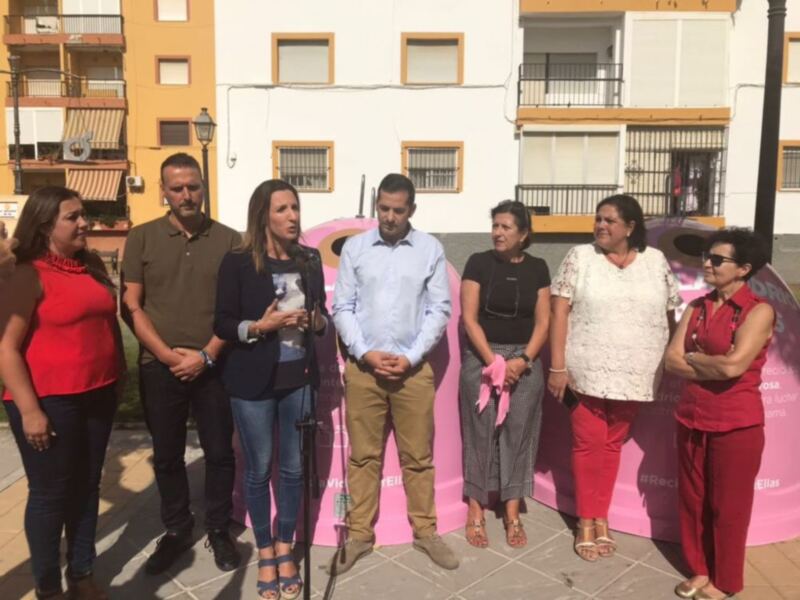 Grupo de personas en evento público frente a edificio residencial.