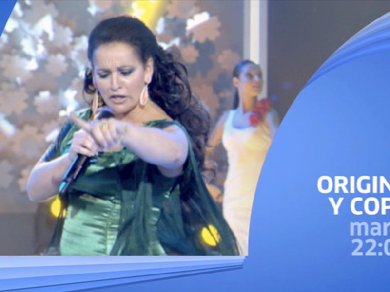 Una mujer cantando en un escenario con un microfono en mano, con un telón de fondo azul y la palabra 'ORIGINAL' en la parte superior derecha de la imagen.