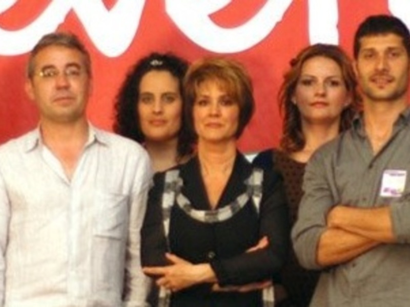 Grupo de personas posando en frente de un fondo rojo con la palabra 'evote' en blanco.