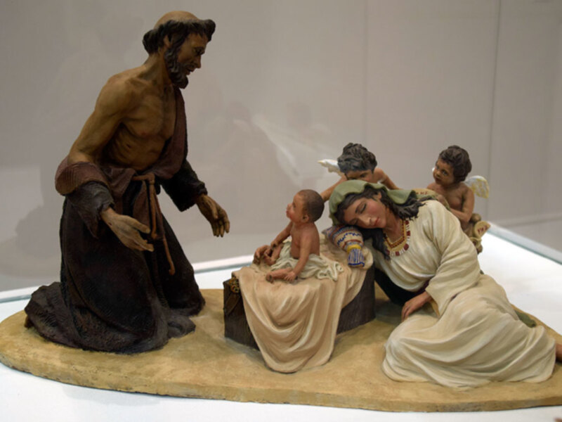 Figurines représentant une scène de nativité avec Joseph, Marie et l'enfant Jésus. Le décor est simple, mettant en avant les personnages principaux.