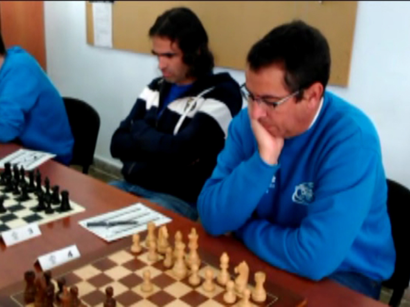 Jugadores concentrados en un torneo de ajedrez en una sala de reuniones.